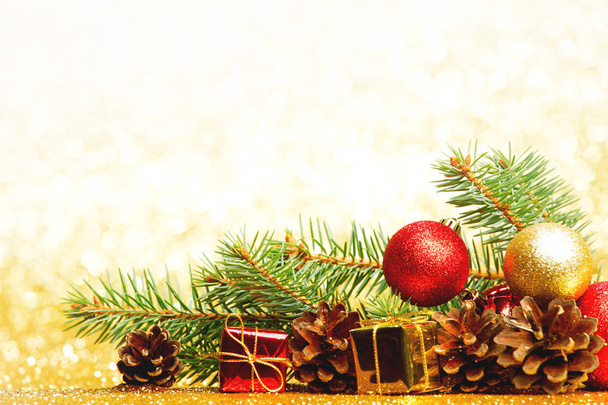Christmas card with fir tree branch and decoration on golden glitter background - Fotografie, Obrázek