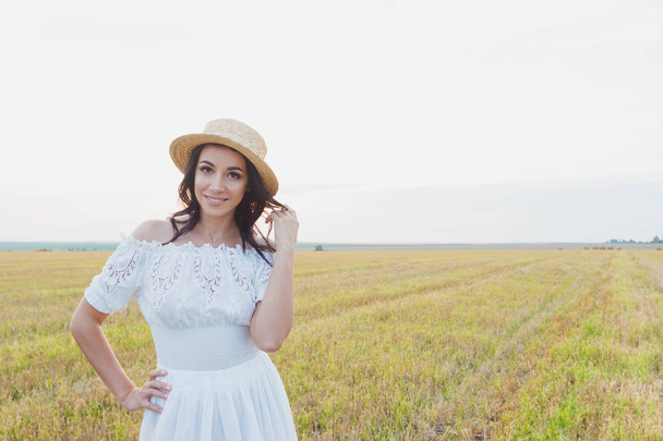 Piękna młoda kobieta w białej sukni na tle pola, soft focus - Zdjęcie, obraz