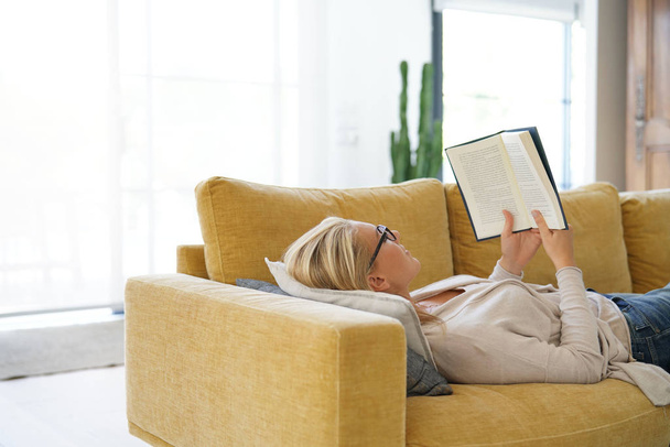 Middle-aged woman at home reading book - Fotoğraf, Görsel