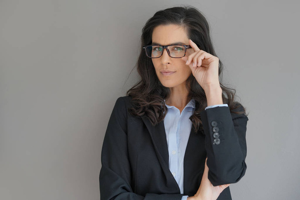 Businesswoman with spectacles standing on grey background - Zdjęcie, obraz