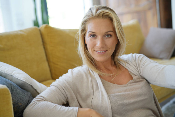 Portrait of attractive blond woman relaxing in sofa - Foto, Imagem