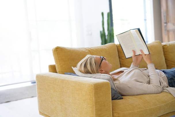 Middle-aged woman at home reading book - Photo, image