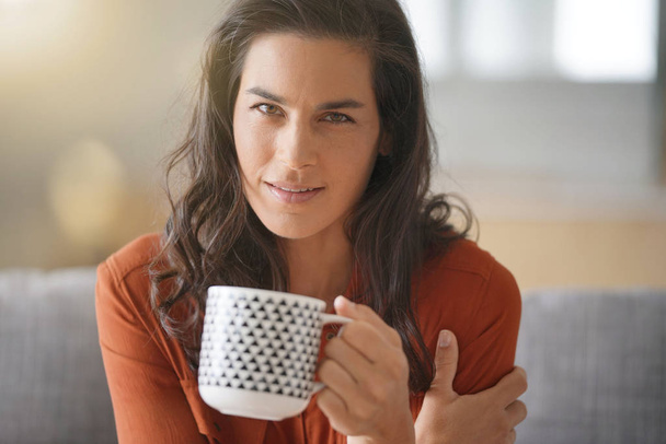 Portrait of attractive brunette woman drinking tea - Foto, Bild