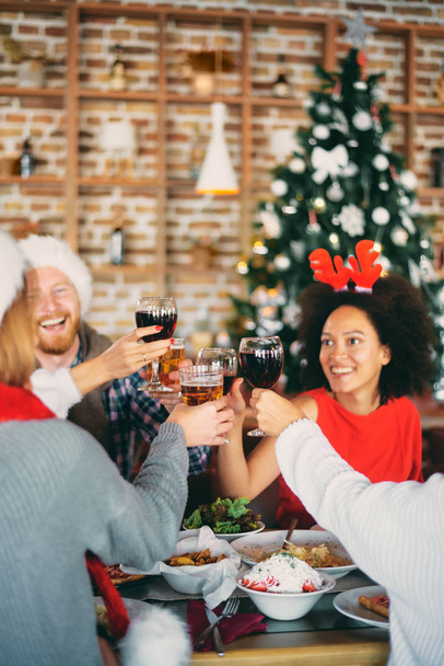Vrienden drinken van alcohol en diner voor kerstavond thuis hebben. Kerst vakantie concept. - Foto, afbeelding