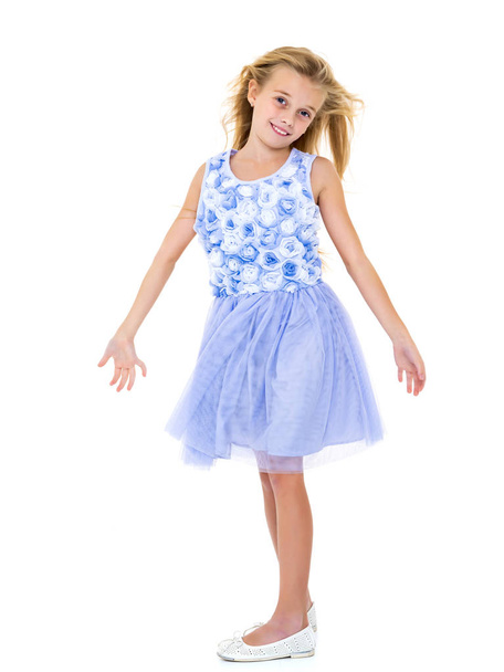 Little girl in a dress developing in the wind. - Фото, зображення