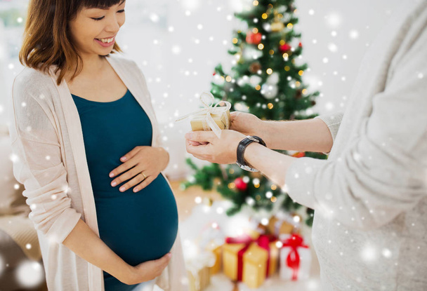 husband giving christmas present to pregnant wife - Фото, изображение