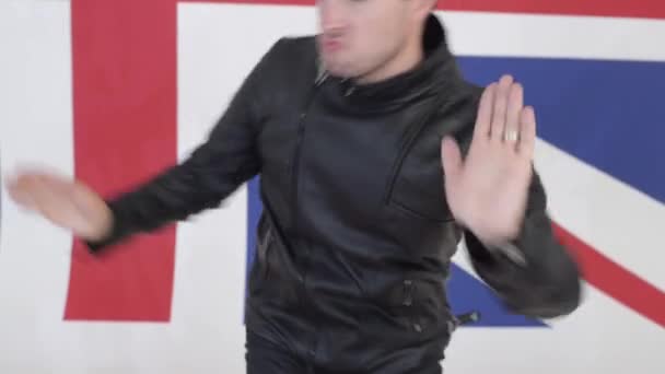 Csinos, fiatal férfi viselt fekete bőr motoros kabátok aktívan táncok - Felvétel, videó
