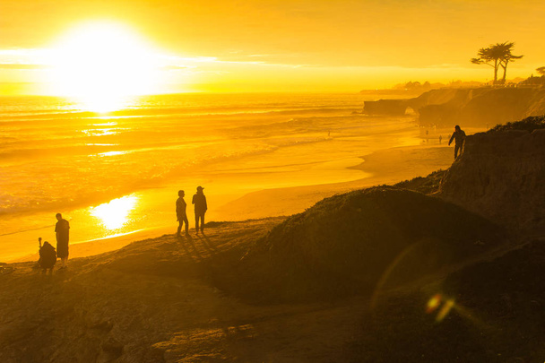 People enjoying the view of a stunningly colorful sunset in Santa Cruz, California in winter - Photo, Image