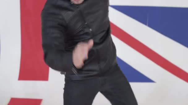 Lindo hombre joven con chaqueta de moto de cuero negro baila activamente
 - Metraje, vídeo