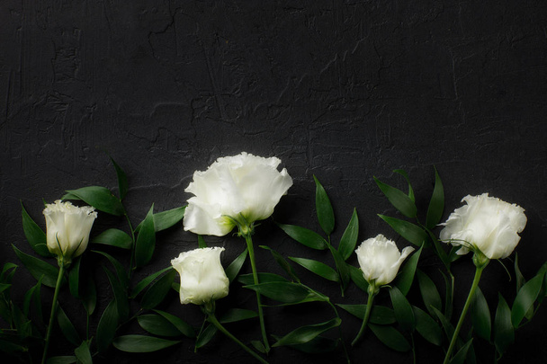 Top view of eustoma flowers and branches over black background - Foto, immagini
