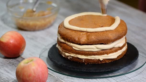 Faire le gâteau aux pommes au caramel dans la cuisine. Chef décorant avec un sac à pâtisserie à la crème
. - Séquence, vidéo