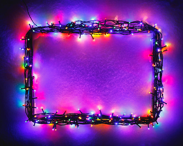 Christmas lights frame on snow background, purple color - Photo, Image