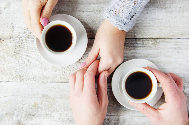 Kopjes met een koffie in de handen van mannen en vrouwen. Selectieve focus. Drink op.. - Foto, afbeelding