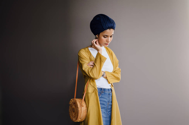 Fashion portrait of a tall, slim, young and attractive Malay Muslim woman wearing fashionable clothing and a turban - Foto, afbeelding
