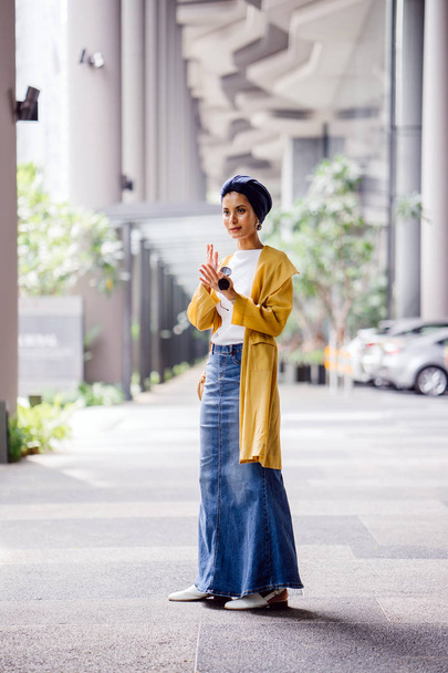 Fashion portrait of a tall, slim, young and attractive Malay Muslim woman wearing fashionable clothing and a turban - Foto, imagen