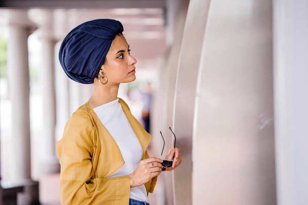 Fashion portrait of a tall, slim, young and attractive Malay Muslim woman wearing fashionable clothing and a turban - Foto, Imagem