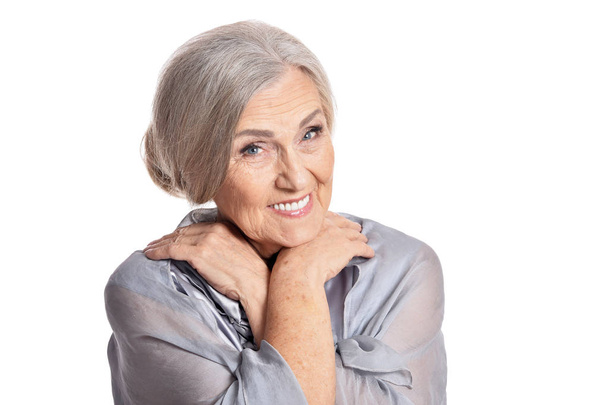 Προσωπογραφία της όμορφης ηλικιωμένης γυναίκας που ποζάρει απομονωμένη σε λευκό φόντο - Φωτογραφία, εικόνα