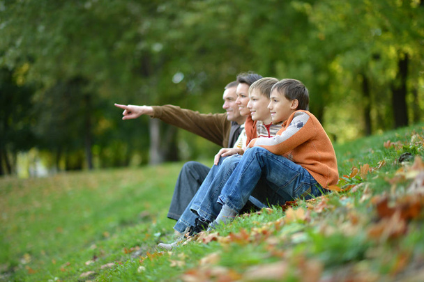 Family of four  in autumn park. Man pointing with finger - Фото, зображення