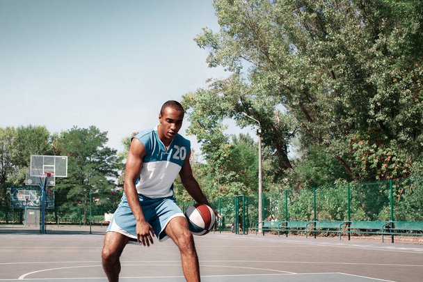 Picture of young confused african basketball player practicing - Foto, Imagem