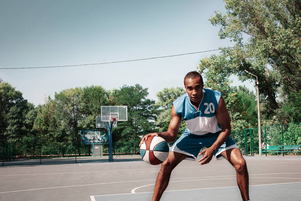 Picture of young confused african basketball player practicing - Fotografie, Obrázek