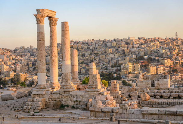 Amman, Jordan its Roman ruins in the middle of the ancient citadel park in the center of the city. Sunset on Skyline of Amman and old town of the city with nice view over historic capital of Jordan. - Photo, Image
