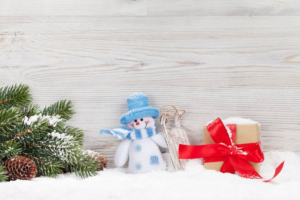 Kerst sneeuwpop toy, cadeau doos en Spar vertakking van de beslissingsstructuur. Xmas wenskaart met ruimte voor uw groeten - Foto, afbeelding