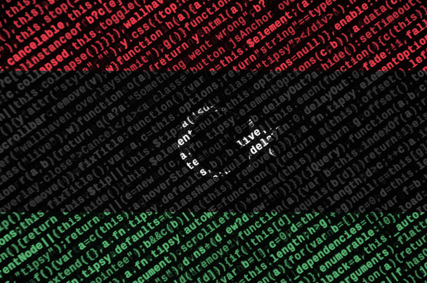 Σημαία της Λιβύης απεικονίζεται στην οθόνη με τον κωδικό προγράμματος. Η έννοια της σύγχρονης τεχνολογίας και τοποθεσία ανάπτυξης. - Φωτογραφία, εικόνα