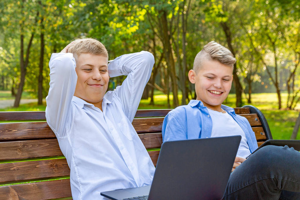 Teenage Boys On Park Bench have fun and relax - Фото, зображення