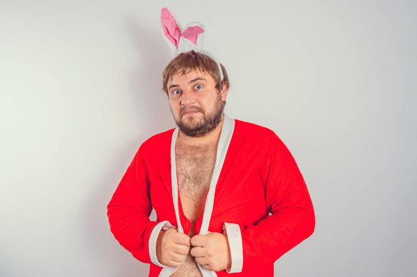 Emotional fat man with a beard. in a red coat with Bunny ears. isolated on white - Foto, immagini