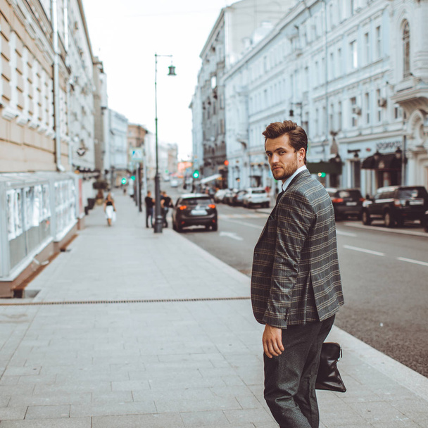 stylish Caucasian gentleman in tweed suit jacket walking in street at road with cars  - Zdjęcie, obraz