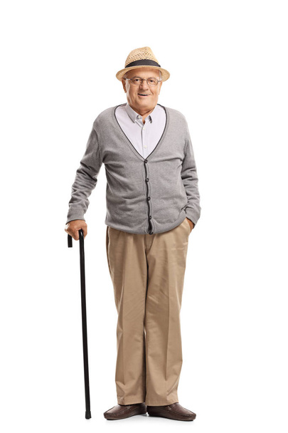Volledige lengte portret van een senior man die met een stok geïsoleerd op witte achtergrond - Foto, afbeelding