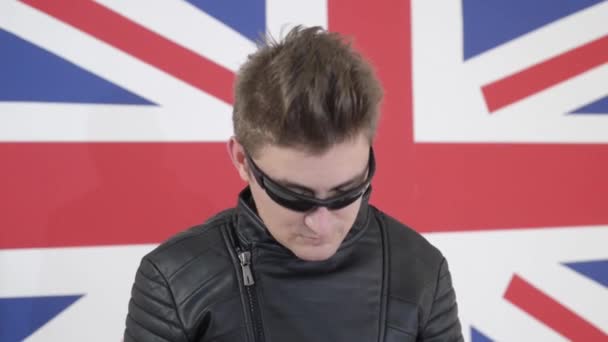 Yakışıklı olan deri motosiklet ceket pozlar ve güneş gözlüklü - Video, Çekim