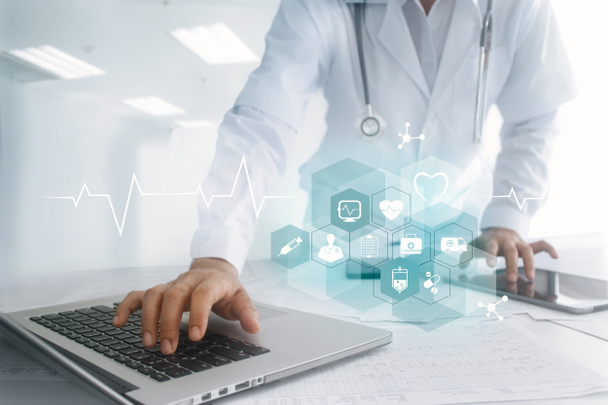 Ιατρική γιατρός χέρι αγγίζει διασύνδεση υπολογιστή laptop και tablet ως ιατρική δίκτυο σύνδεση με εικονίδιο σύγχρονο στην εικονική οθόνη, ψηφιακή υγειονομική περίθαλψη, ιατρική τεχνολογία δικτύου και καινοτομία ιδέα - Φωτογραφία, εικόνα