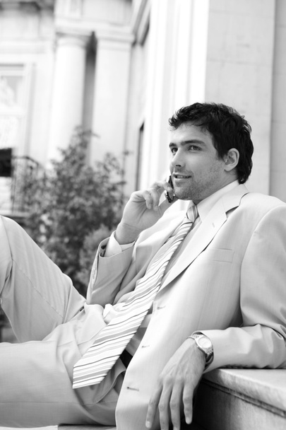 černobílý portrét atraktivní podnikatel bavit na jeho mobilní telefon - Fotografie, Obrázek