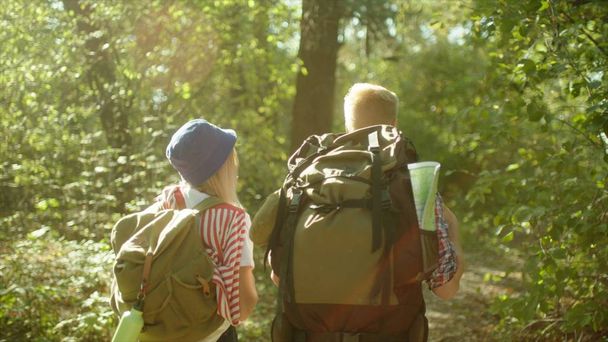 Young couple hiking with backpacks and the map of park on summer time - Foto, Imagem