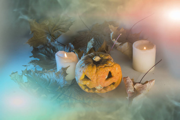 Απόκριες κολοκύθας με κεριά και φθινόπωρο αφήνει στο ομιχλώδες φόντο κλίση - Φωτογραφία, εικόνα
