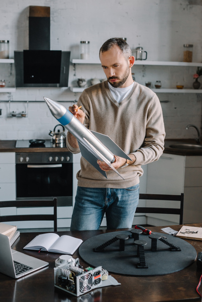 Ingeniero guapo diseñando el modelo de cohete en casa
 - Foto, imagen