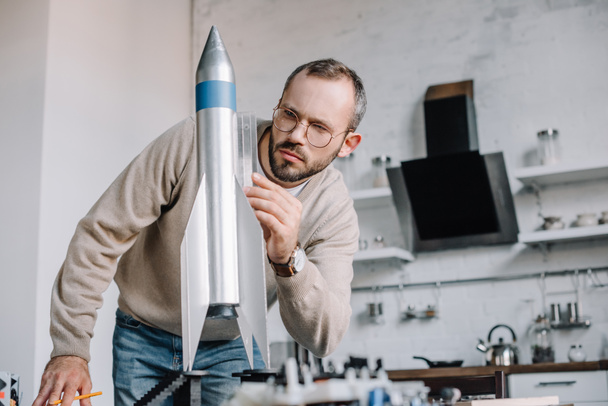 przystojny inżynier modelowania rakiet i pomiaru z władcą w domu - Zdjęcie, obraz