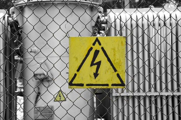 Προειδοποίηση σύμβολο της ηλεκτρικής ενέργειας, υψηλής τάσης, κρέμεται από το φράκτη γύρω από την ηλεκτρική μονάδα. Σύμβολο αστραπή - Φωτογραφία, εικόνα