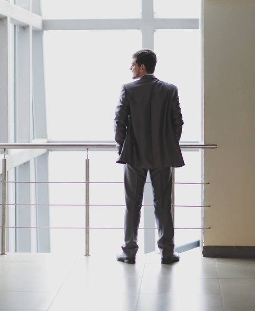 Taustakuva. liikemies seisoo aulassa modernin toimiston
 - Valokuva, kuva