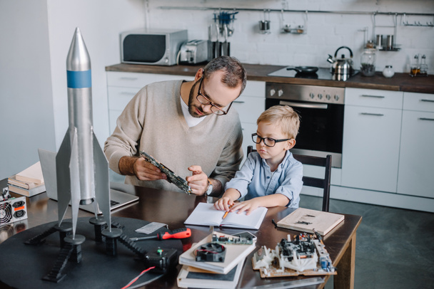 father and son repairing microcircuit at home - Φωτογραφία, εικόνα