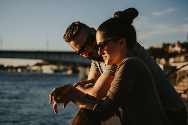 Couple in love smiling in the sunset by the river. Beautiful sunny day - Fotoğraf, Görsel