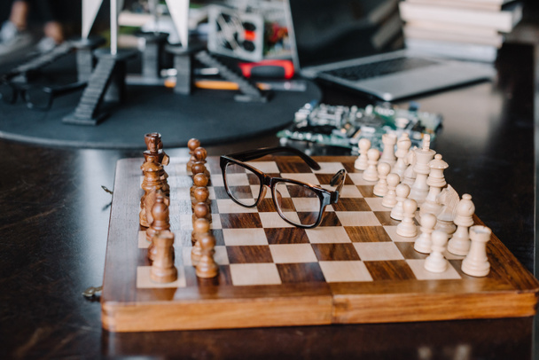 wooden chess board with glasses on table in living room - Photo, Image