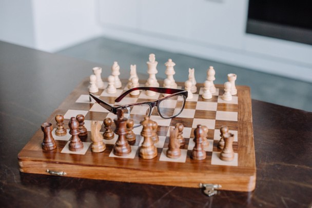 chess board with glasses on table in living room - Zdjęcie, obraz