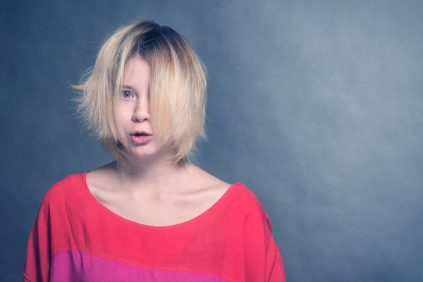 Sad blonde girl teenager in a red blouse - Foto, Imagen