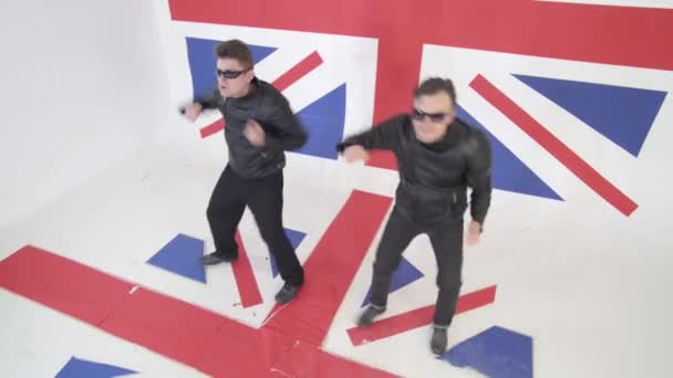 Energikus srácok napszemüveg és fekete bőr motoros kabát táncolnak. - Felvétel, videó