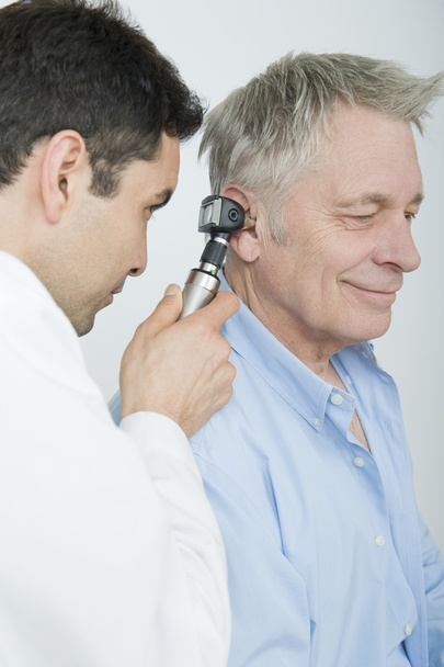 Doctor Examining Patient's Ear Using Otoscope - 写真・画像