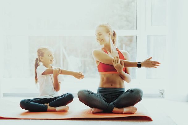 Mum And Daughter Yoga Training. Lotus Position. Active Lifestyle. Relaxing Together. Doing Fitness At Home. Holiday Leisure. Body Balance. Sport Exercise. Sunny Day. Arms Crossed Pose. - Foto, Imagem