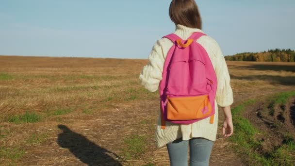 Νεαρή γυναίκα με ροζ σακίδιο περπάτημα - Πλάνα, βίντεο