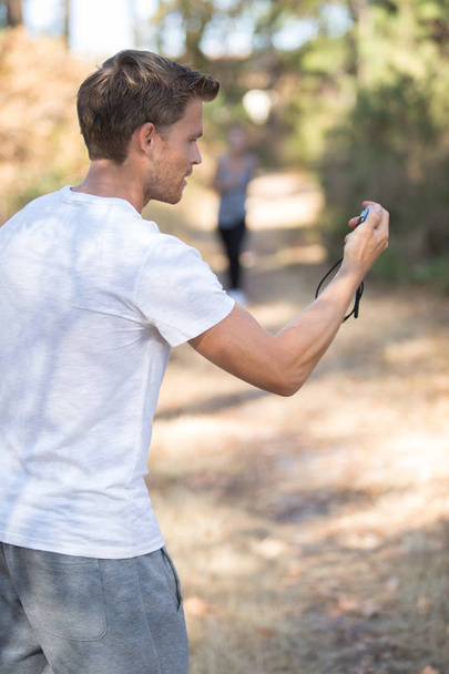man holding a stopwatch on running trails - 写真・画像